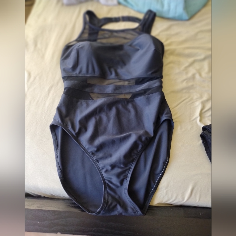 Black one piece swimsuit, black with mesh cutouts open back high neck style.